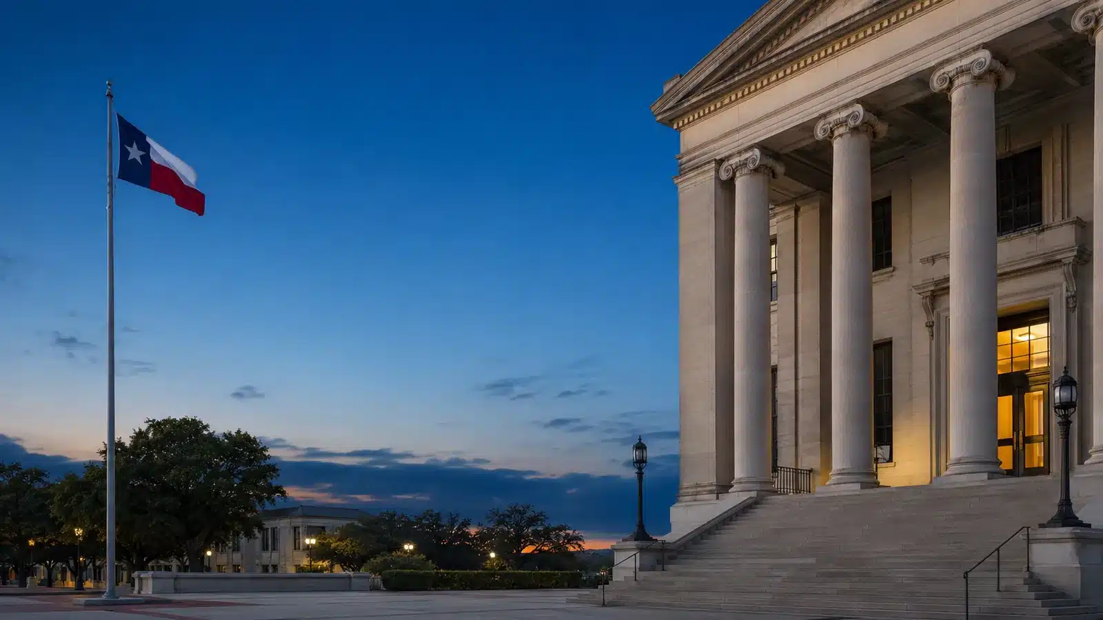 Texas county courthouse columns and a Texas flag at blue hour